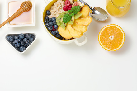 plate with oatmeal and fruit, half a ripe orange and freshly squ, a Food & Drink Photo by ndanko