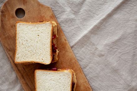 Homemade Peanut Butter and Jelly Sandwich on a rustic wooden boa, a Photo by LiudmylaChuhunova