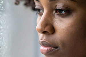 Woman looking outside through rainy window with thoughtful gaze, a Person Photo by GoodGoods