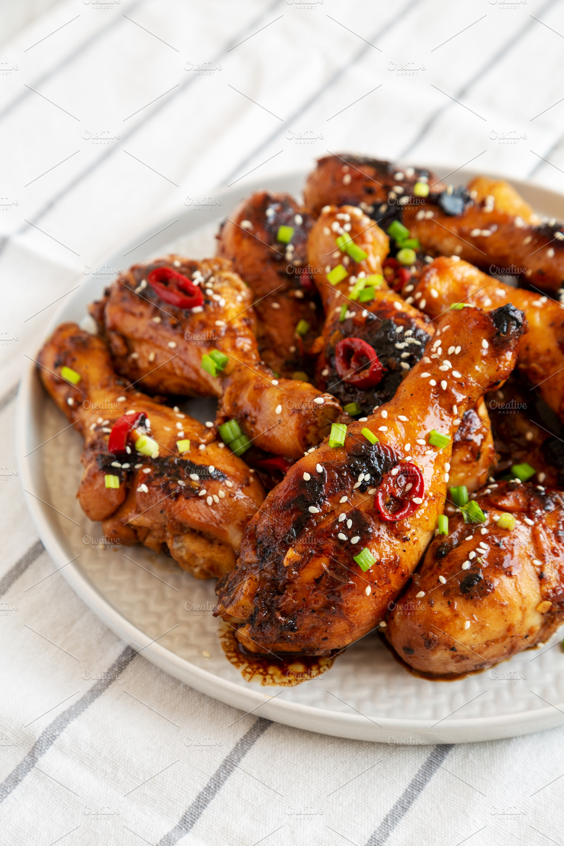 Homemade Easy Sticky Chicken Drumsticks on a Plate, side view. C, a Food & Drink Photo by LiudmylaChuhunova