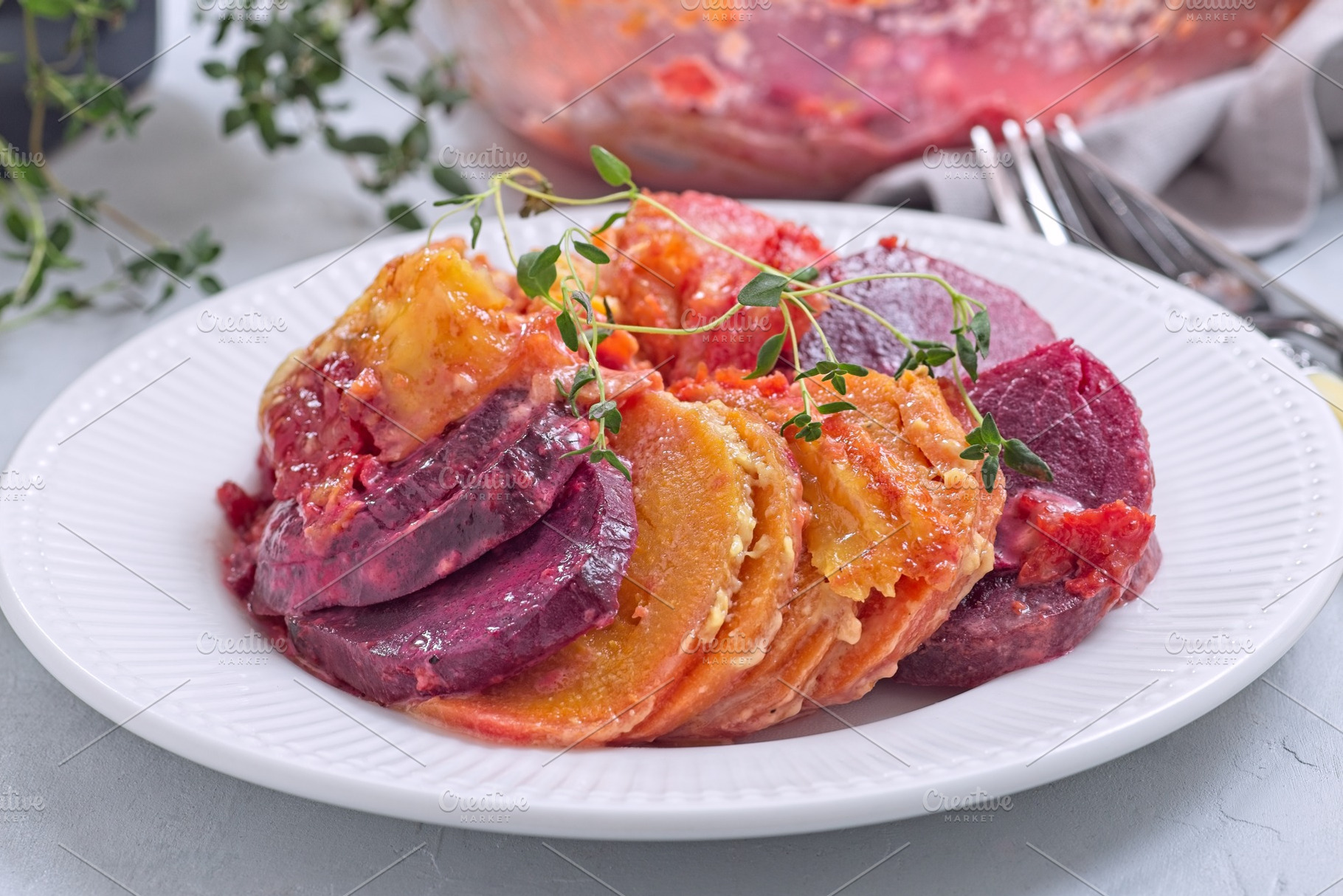Sweet potato, parsnips and beet root gratin with thyme and melted cheese, on wh, a Food & Drink Photo by iuliia_n