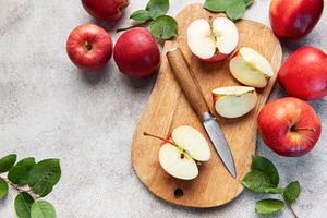 Fresh red apples and slices with knife on wooden cutting board, a Food & Drink Photo by Olena Rudo