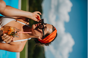 Young woman sitting by swimming pool, a Person Photo by HalfPoint