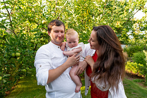 Parents hold curious baby among appl, a Person Photo by Elena Vagengeim