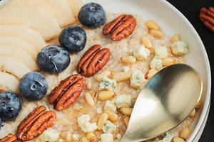 Oatmeal. Bowl of oatmeal porridge with blackberry, bananas and chia seeds on gr, a Food & Drink Photo by Budarinphoto