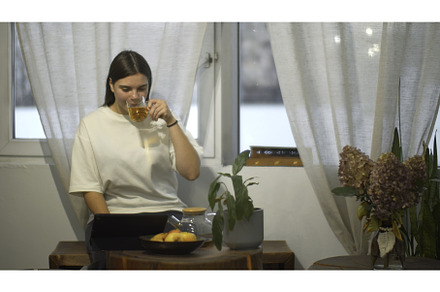 Young woman drinks tea and looks at, a Person Photo by Media Whale Stock