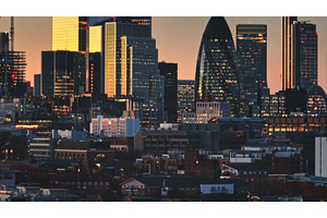 London skyline glowing at sunset, an Architecture Photo by Goinyk