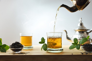 Pouring Moroccan tea from a metal teapot into a glass, a Food & Drink Photo by Davizro's Market