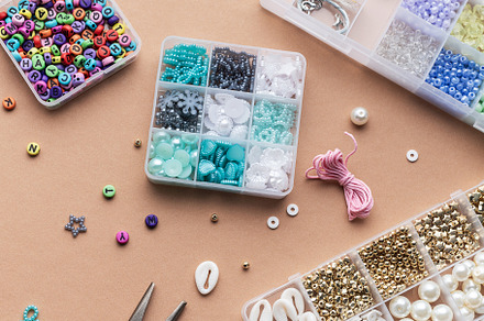 Crafting with colorful beads on a flat workspace with tools and, an Arts & Entertainment Photo by Olena Rudo