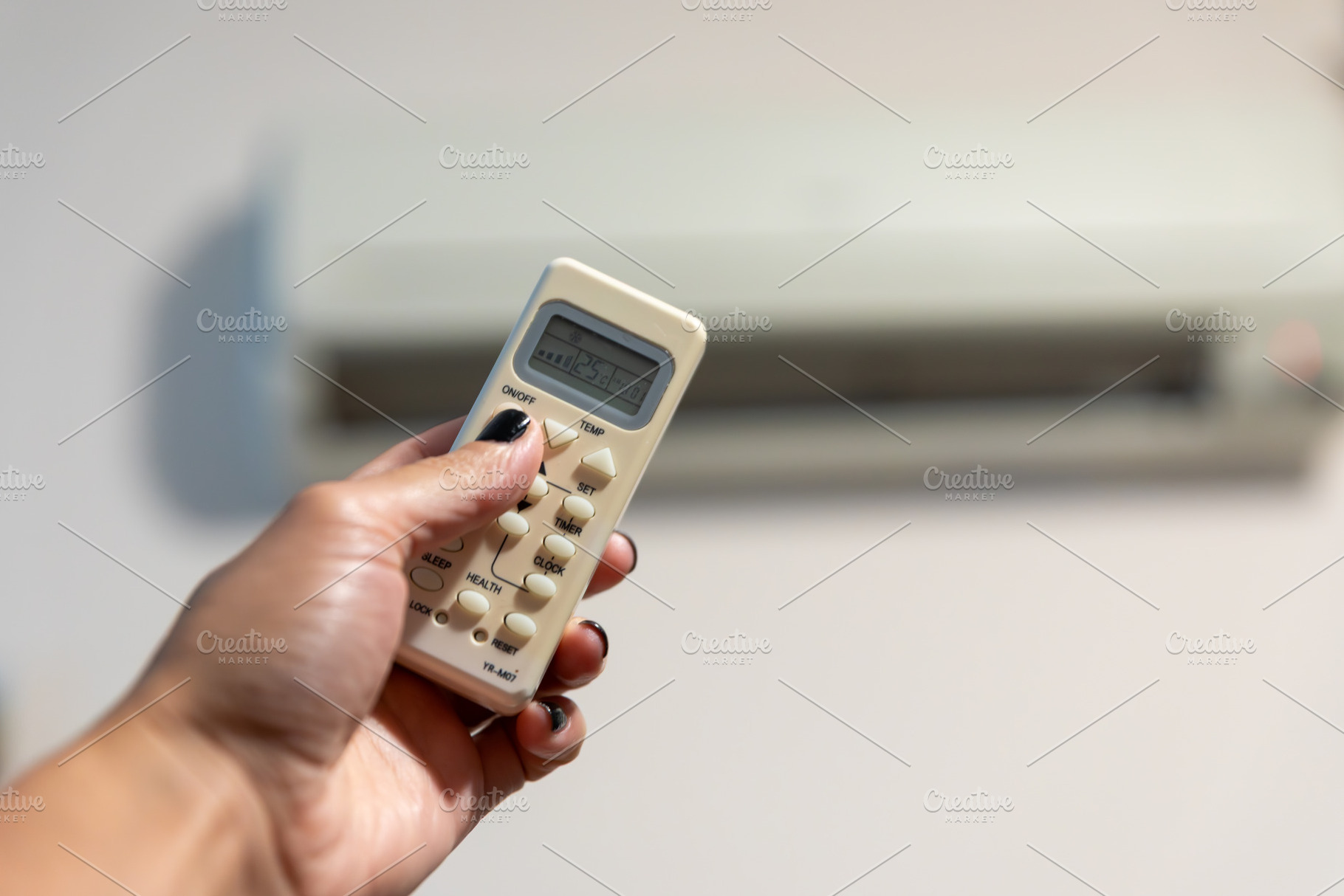 Close-up of a hand using a remote control to operate a wall-mounted air conditi, a Technology Photo by Ales Munt