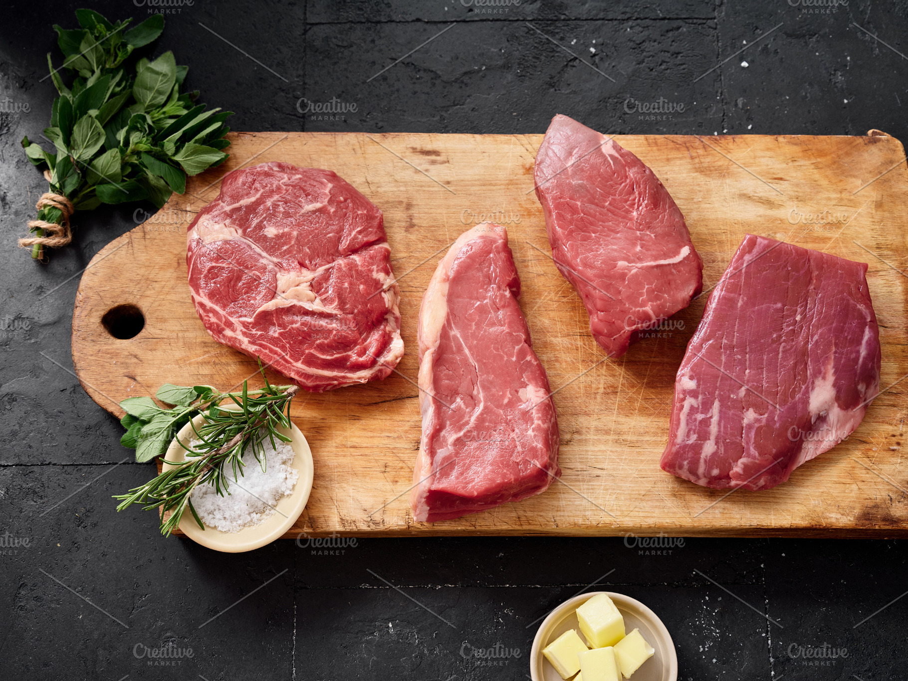 Selection of raw rib-eye, roast beef, flank and rump steak on a wooden cutting, a Food & Drink Photo by Asya Nurullina