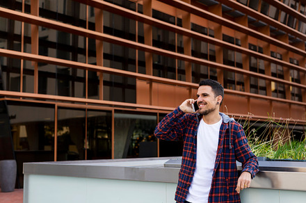 Young man smiling and talking on mobile phone outside, a Person Photo by RF Images