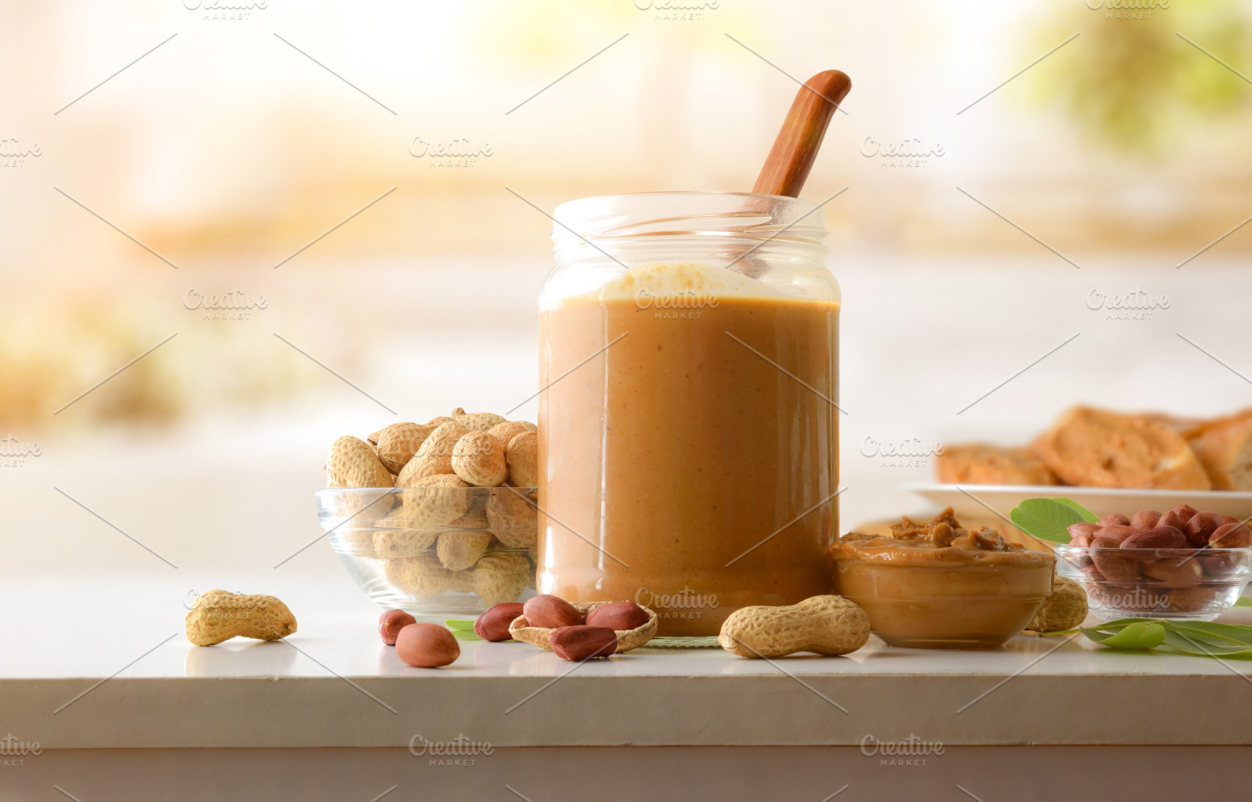 Jar and bowl filled with peanut butter and background cooking, a Food & Drink Photo by Davizro's Market