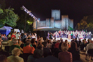 Folk dancers performing at night before medieval castle, a Holiday Photo by DanFLCreativo