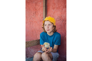 Child spends time with a chick, a Person Photo by Elizaveta Galitskaya