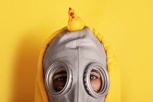 Close-up of a person in a gray gas mask and yellow hoodie with a, a Person Photo by Ales Munt