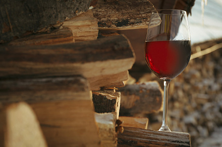 Glass of wine outdoor on folded firewood, a Nature Photo by AtlasStudio PRO