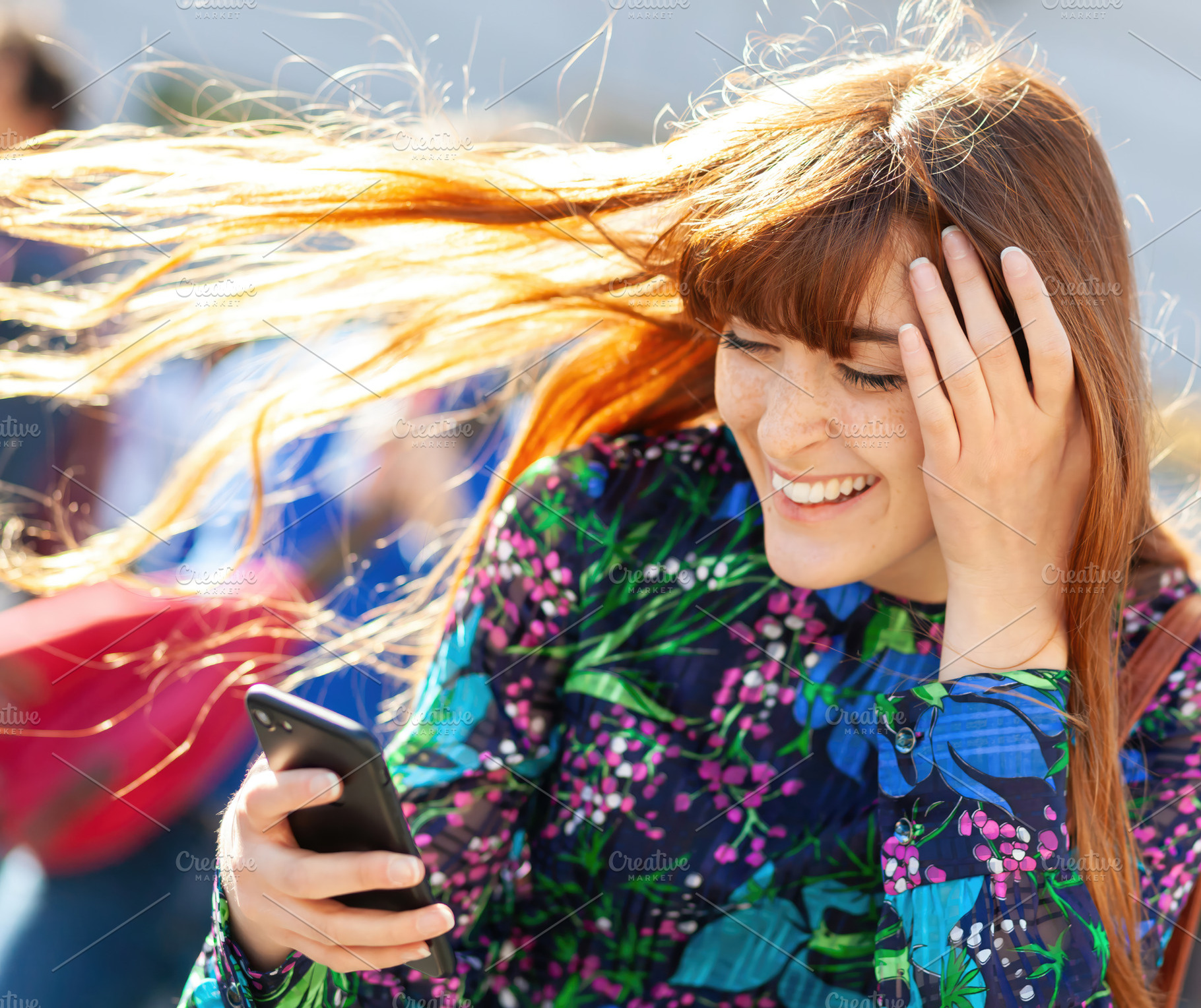 Redhead young woman laughing while looking at her smartphone and holding her ha, an Abstract Photo by Antonio Gravante Market