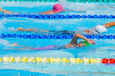 Swimmer child swims freestyle swimming style in a race swimming