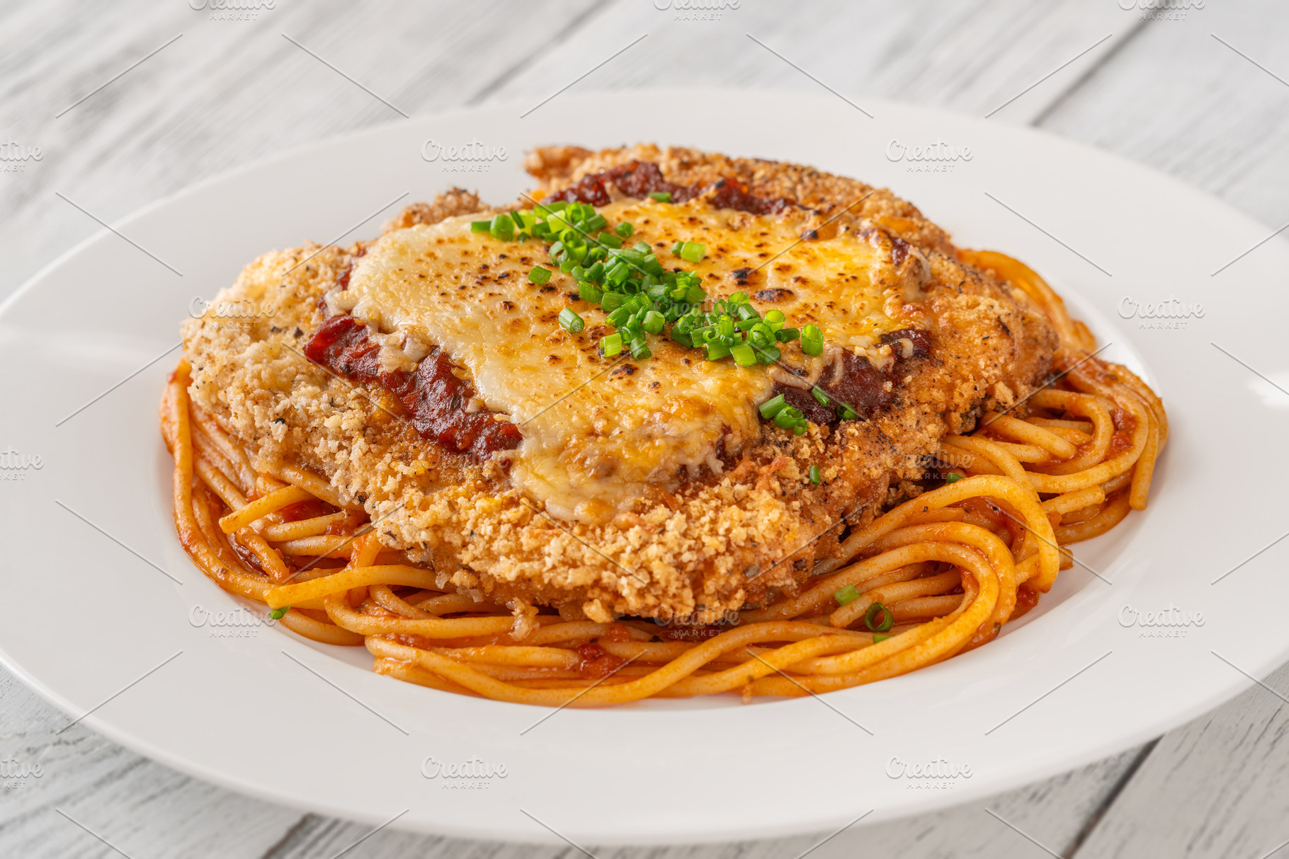 Crispy Chicken Parmesan served over, a Food & Drink Photo by Alexander Prokopenko