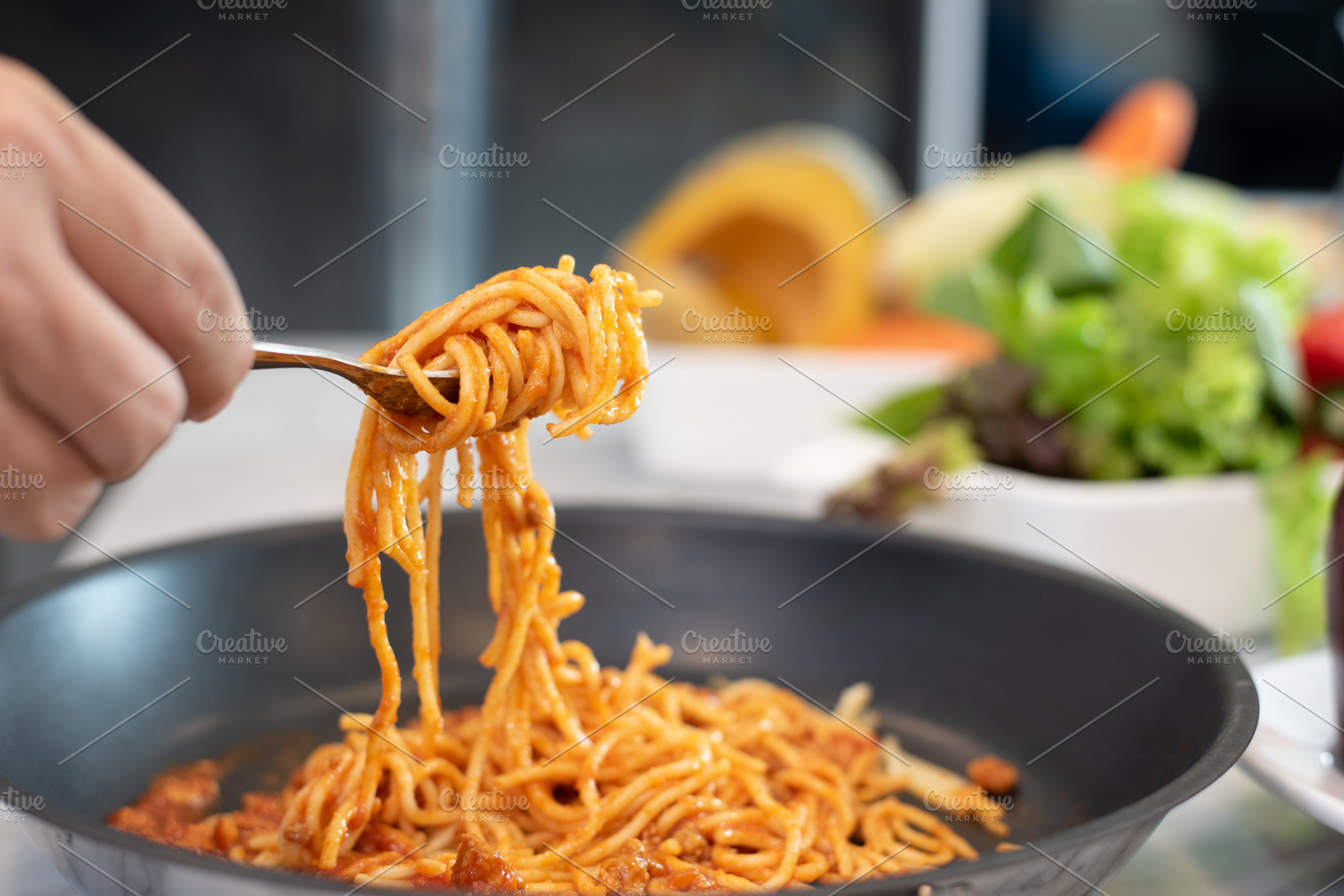 Spaghetti lifted by fork with vegetable salad and dish backgroun, a Food & Drink Photo by Ministocker