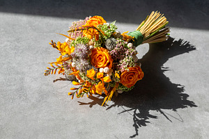 Top-down view of a flower bouquet made of orange roses and purpl