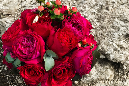 Elegant bridal bouquet with red roses and wedding rings, a Photo by AS photostudio