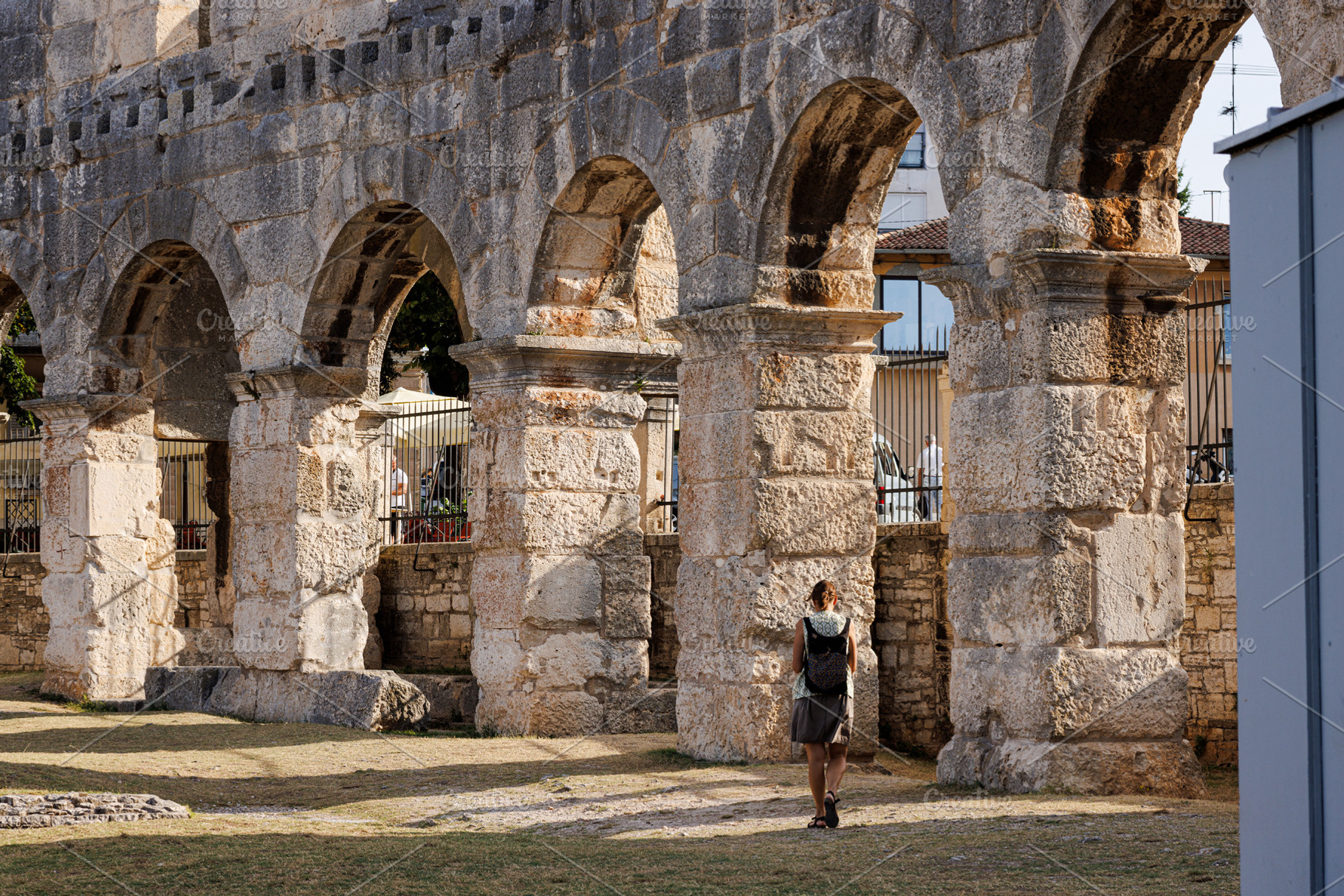 The woman enjoy the scenic view of Pula Arena amphitheatre, an Architecture Photo by Bepslabor
