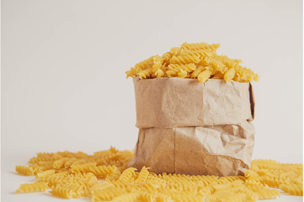 Spiral pasta in a paper bag on a, a Food & Drink Photo by olhovyi_photographer