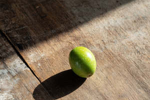 Single Olive on Aged Wooden Table, a Food & Drink Photo by Virgo Studio