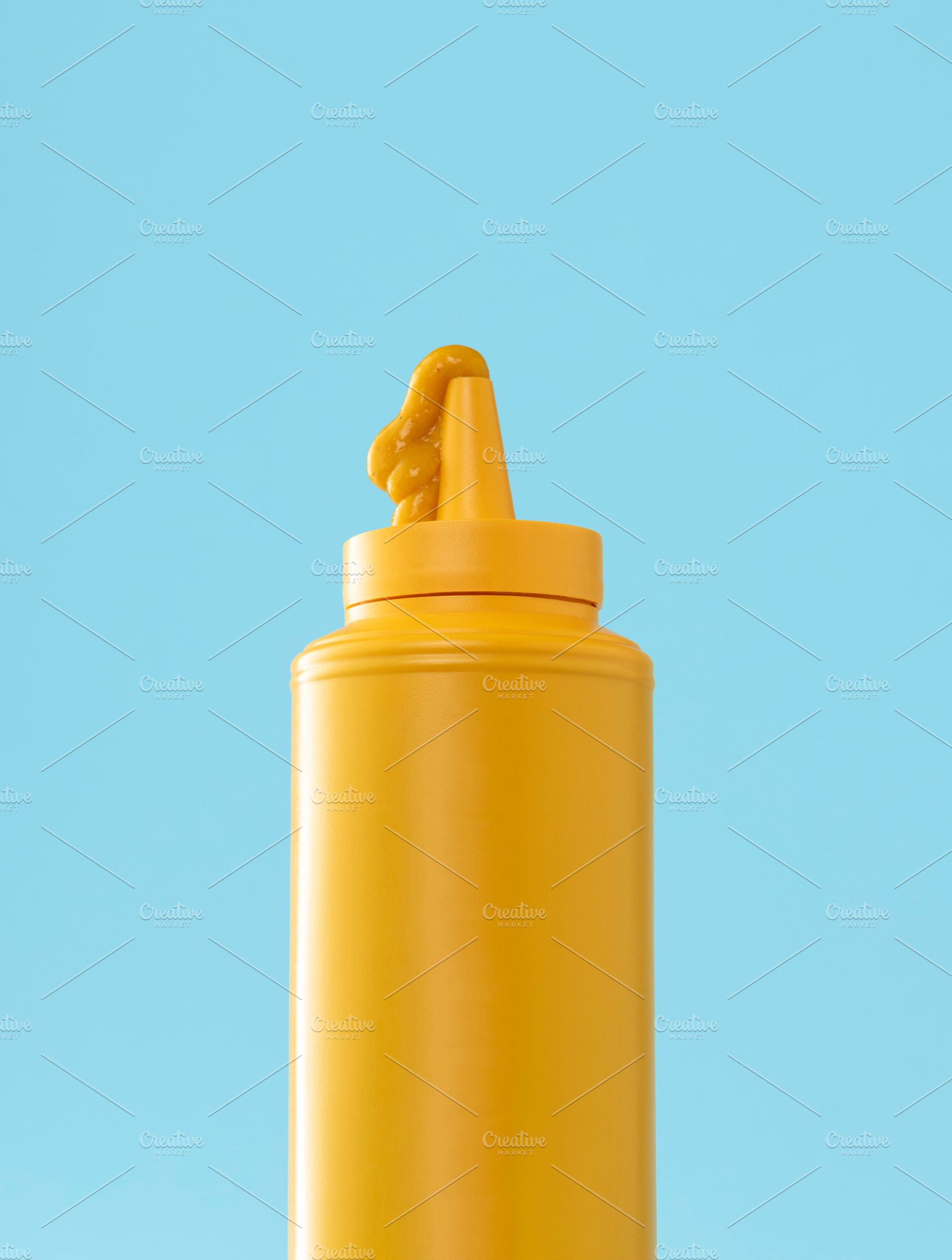 Mustard plastic bottle isolated on a blue background., a Food & Drink Photo by YesPhotographers