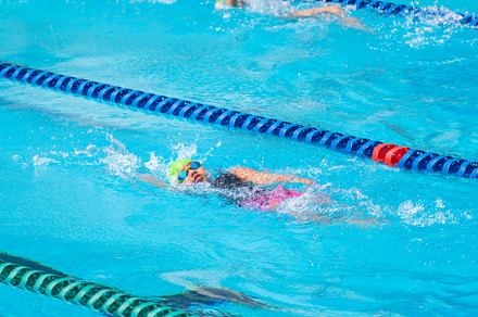 Swimmer child swims backstroke swimming style in a race swimming