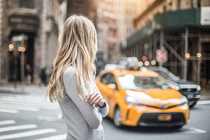 woman on city street wait for taxi