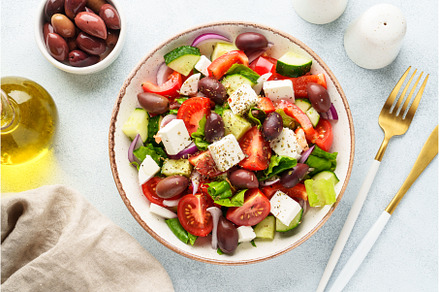 Greek salad in craft plate on white