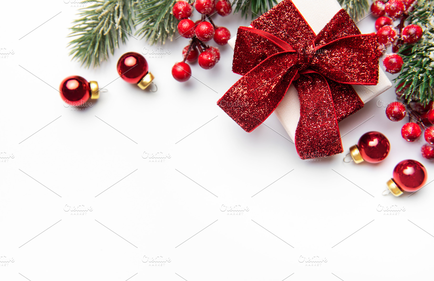 Christmas gift box with festive red decorations on white, a Holiday Photo by Olena Rudo