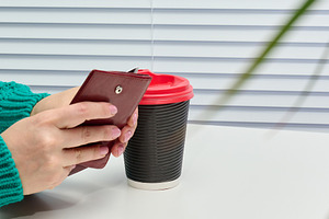 Female hands in a green sweater holding an open wallet near a pa, a Person Photo by ndanko