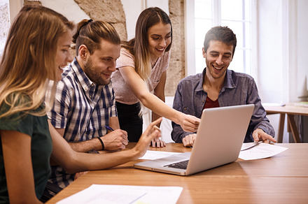 Young business team working featuring businessmen, businesswomen, and laptop