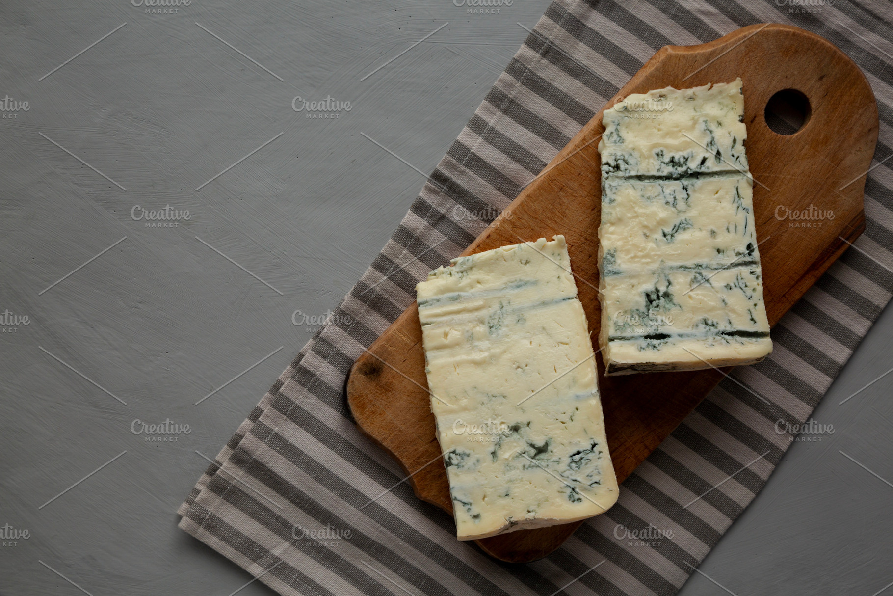 Blue cheese Gorgonzola on a Wooden Board, top view. Space for te, a Food & Drink Photo by LiudmylaChuhunova