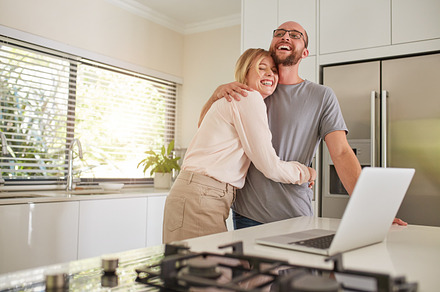 Loving couple with laptop in kitchen, a Person Photo by Jacob Lund