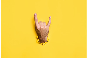 Rock sign gesture through hole in, a Person Photo by Gladkov photography