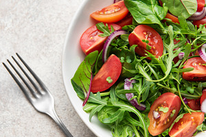 Fresh vegan salad with arugula, tomatoes, and red onion, a Food & Drink Photo by Olena Rudo