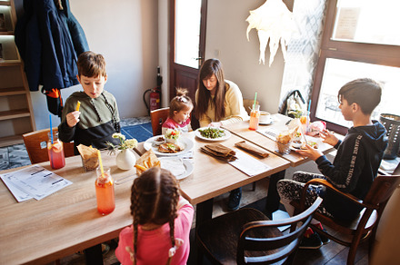 Mother with four kids spending time in cafe. Family lunch in the, a Person Photo by AS photostudio