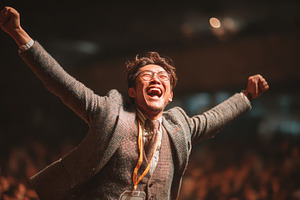 Joyful asian man celebrating success at business event among a cheering crowd, a Business Photo by AS photostudio