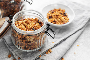 Granola cereal in glass jar ready for healthy breakfast, a Food & Drink Photo by Olena Rudo