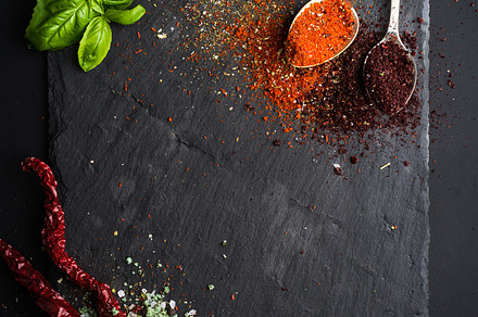 Herbs and spices on black board containing pepper, black, and cuisine, a Food & Drink Photo by Foxys