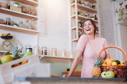 Smiling woman standing at a juice ba, a Food & Drink Photo by Jacob Lund