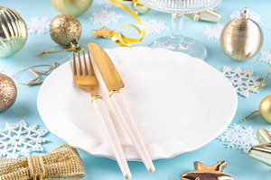 Christmas, New Year table setting with plate, drinking glass, cu
