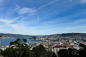 Panoramic view of Vigo cityscape and harbor under a vibrant blue sky, a Photo by AS photostudio