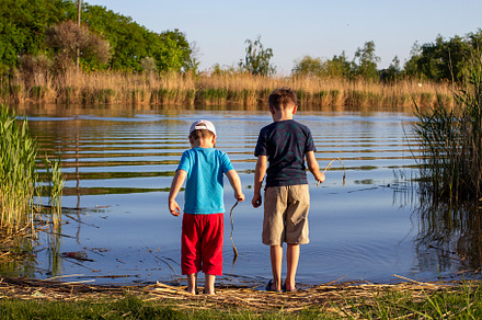 Two boys standing on river., a Person Photo by Anno Urbis