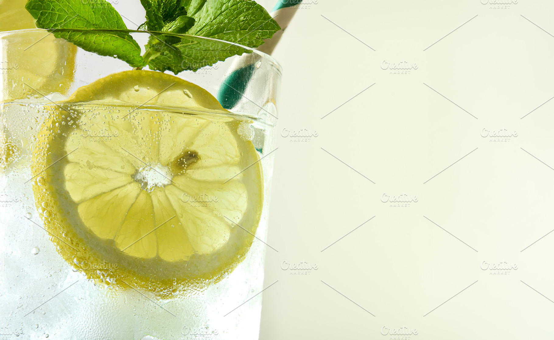 Refreshing drink with lemon, ice and mint with light background, a Food & Drink Photo by Davizro's Market
